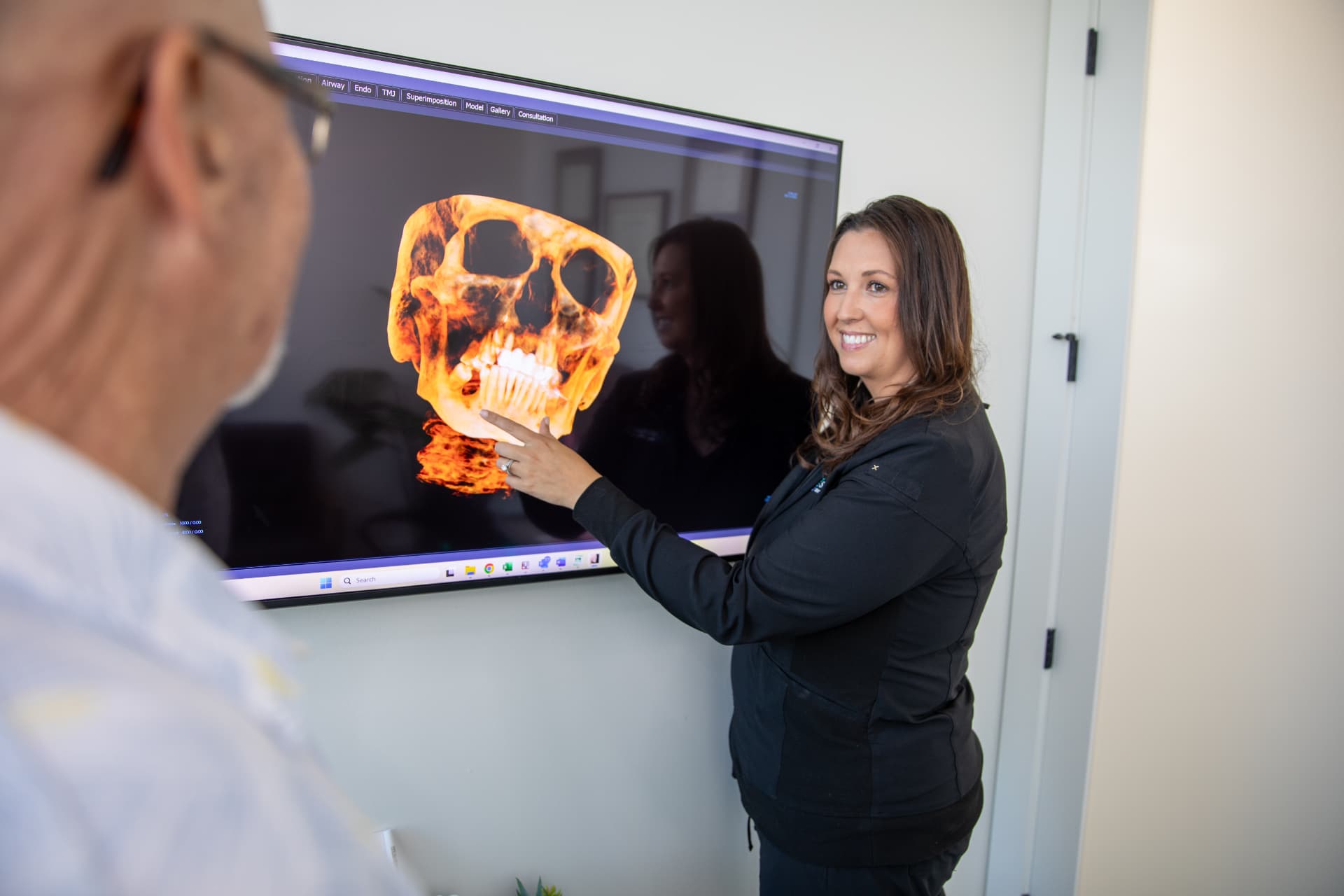 Dr. Melani Kapetanakos reviewing a 3D CBCT scan with a patient in Sarasota, FL